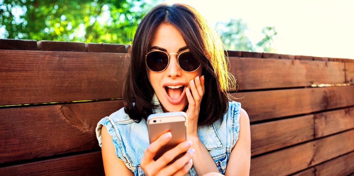 shocked woman looking at her phone after taking the Rice Purity Test