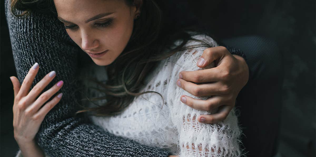 man cuddling woman