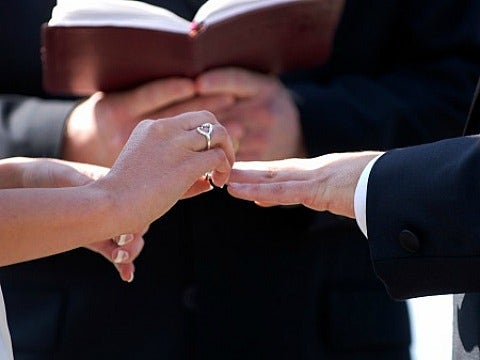 Fake Marriages In China: When Gay Men Marry Lesbian Women couple putting ring on finger in marriage ceremony