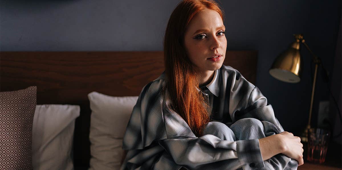 unhappy girl sitting alone on her bed