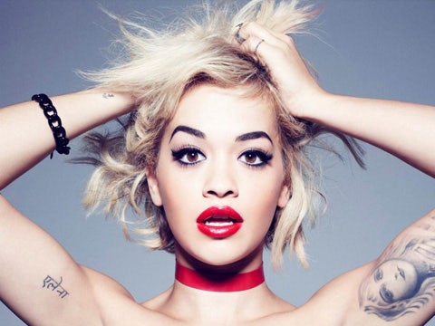 Rita Ora, from the shoulders up, wearing black eyeliner and red lipstick in a Rimmel ad