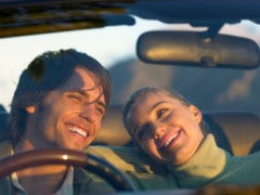 5 Male-Suggested Road Trip Must-Haves a couple laughing as they are driving in car