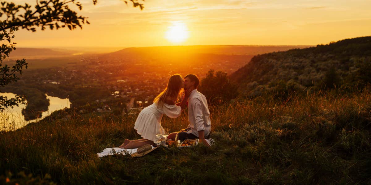 couple having romantic picnic at sunset
