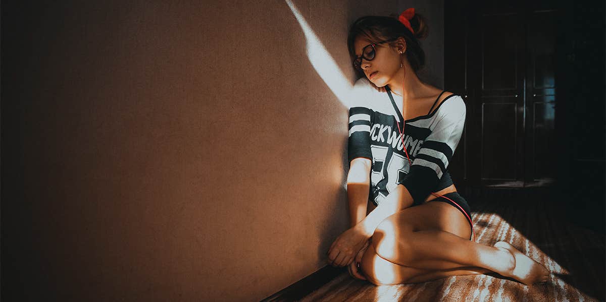 11 Signs Your Root Chakra Is Blocked & How To Unblock It woman sitting on the floor
