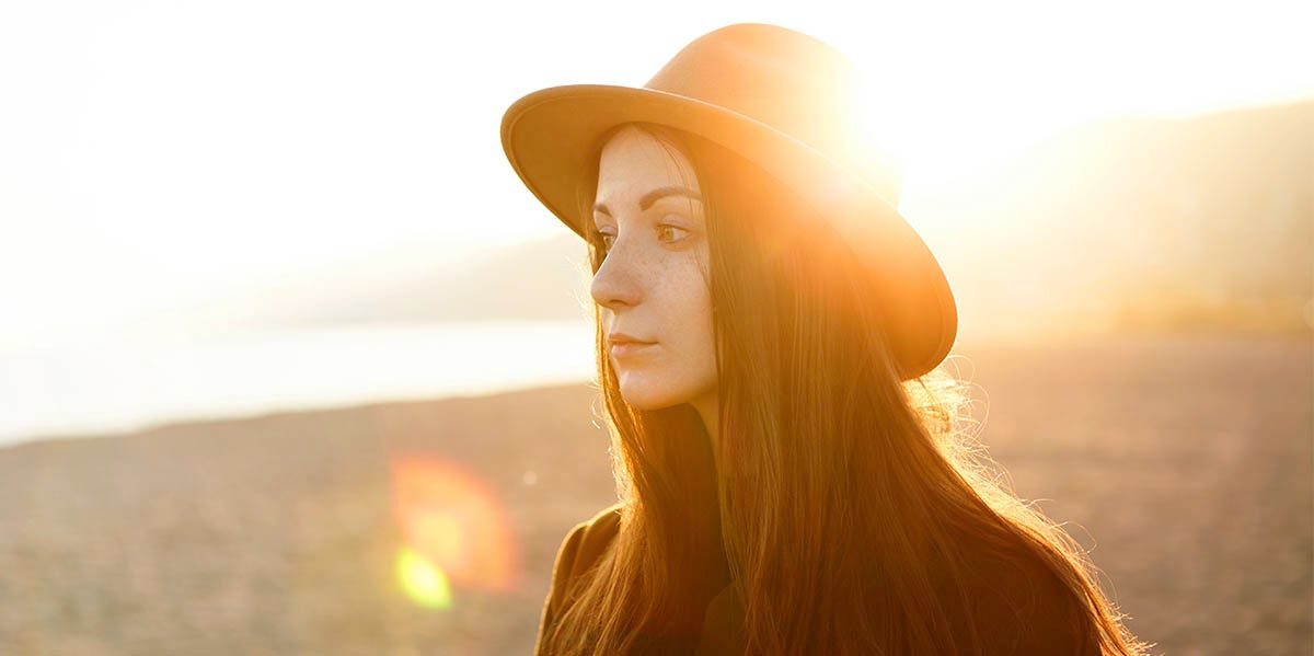 woman staring with sunset behind her