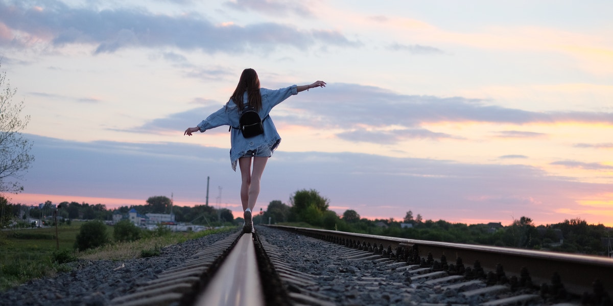 girl walking along train tracks