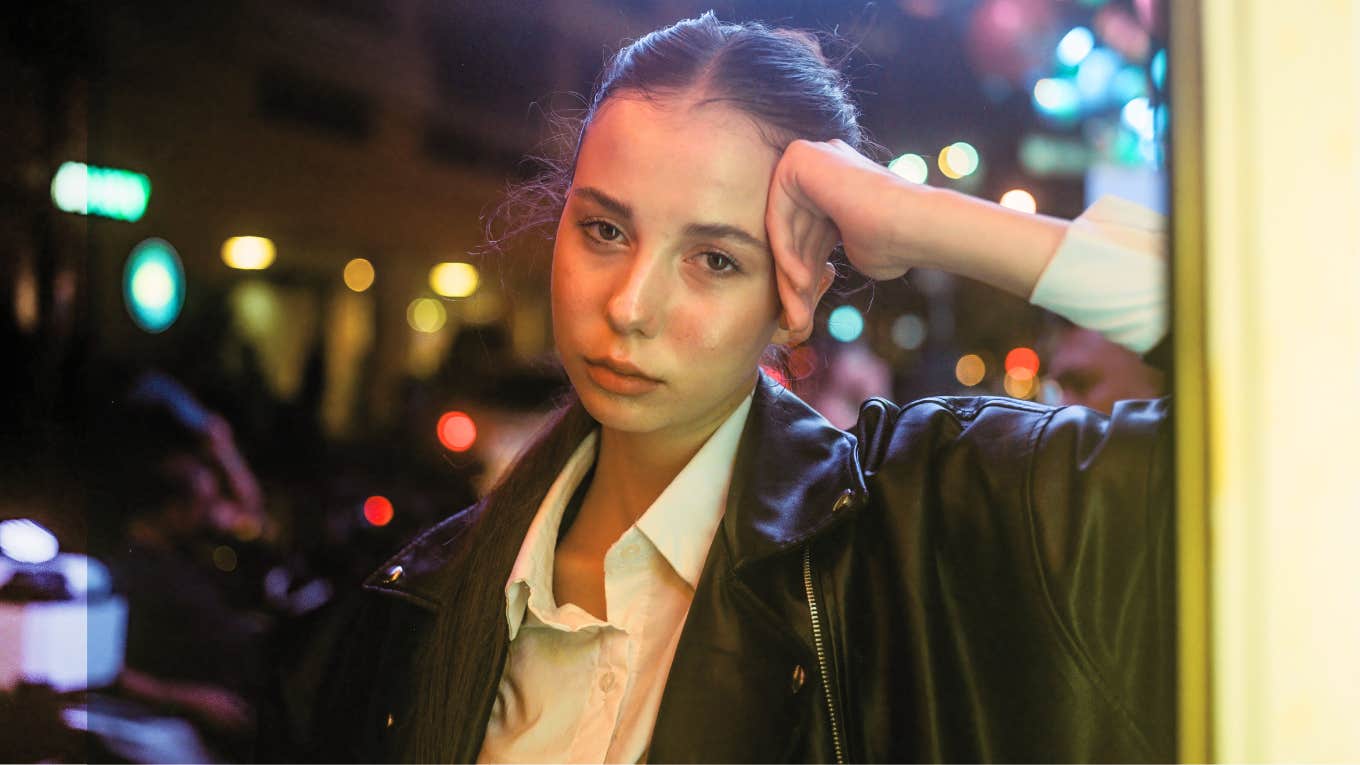 Sad Reasons Women Think They'll Never Find True Love Sad woman out on the town, leaning against the building