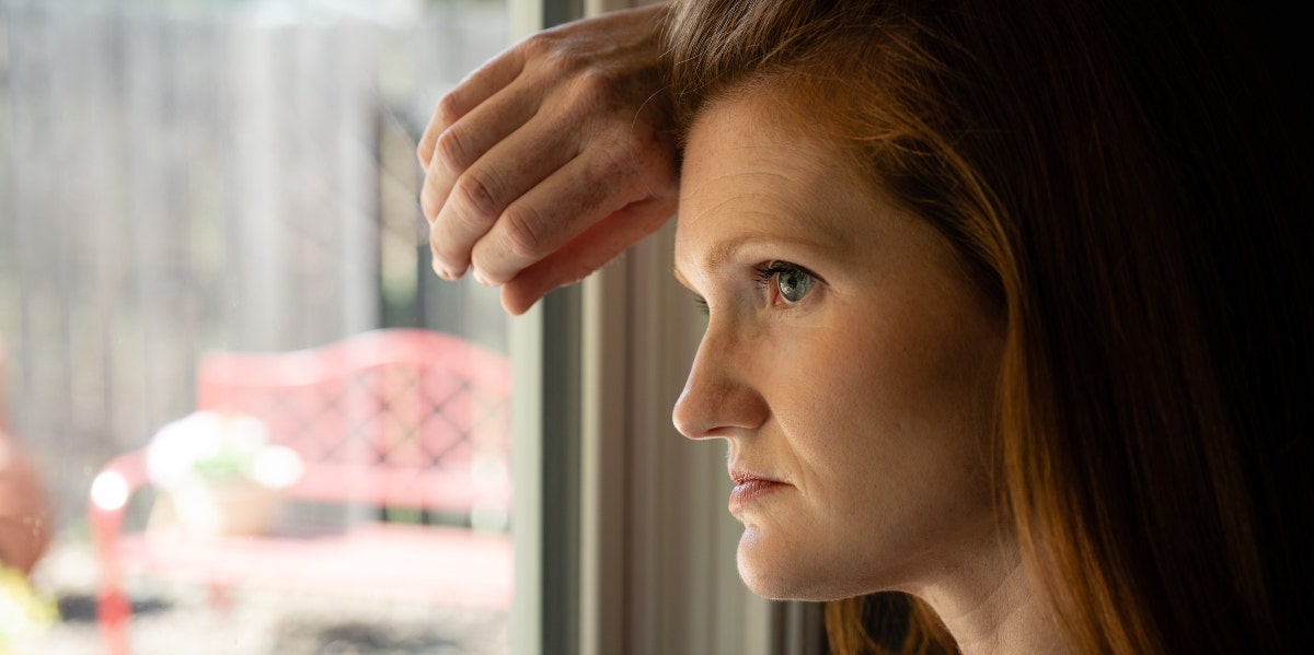 sad woman looking out the window