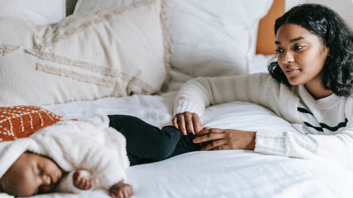 mom and baby lying on bed