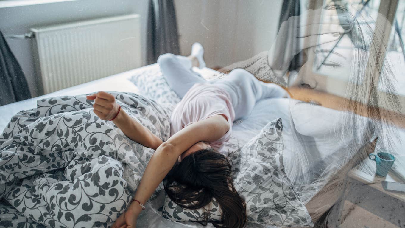 Woman with a headache, laying in bed