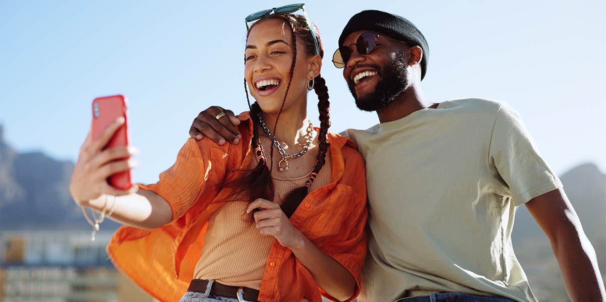 man and woman laughing taking selfie