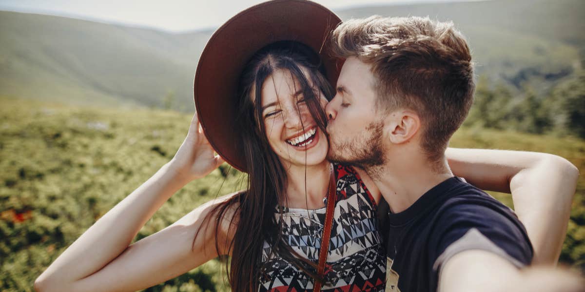 man kissing woman