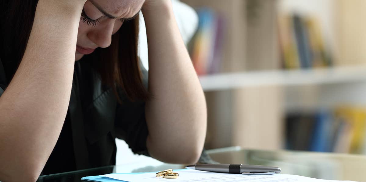 upset woman looking at divorce papers