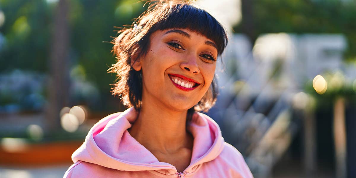 The Secret To Being Captivating — Literally smiling girl in pink hoodie
