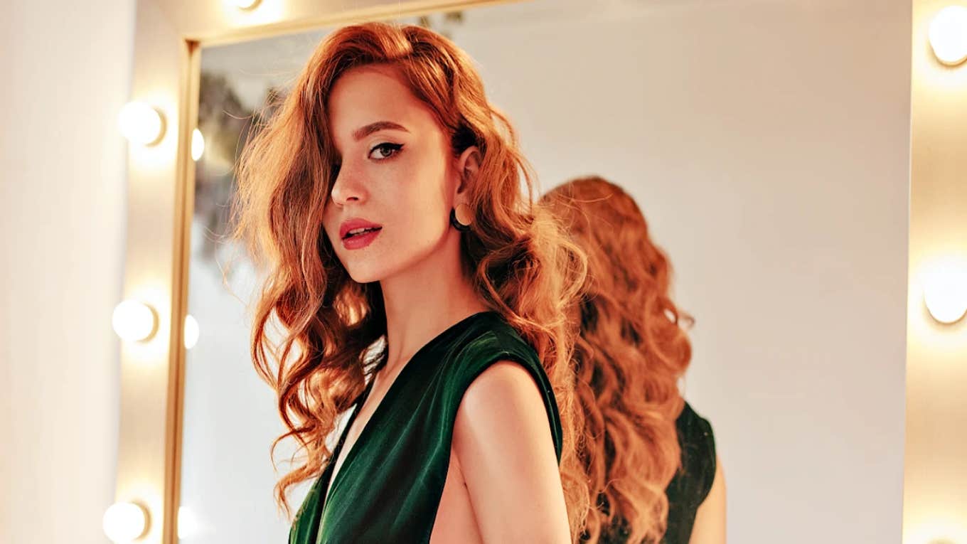 glamorous woman with red hair in a green dress