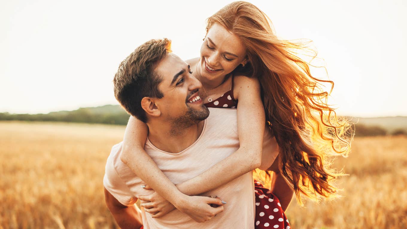 happy couple looking at each other hugging from behind