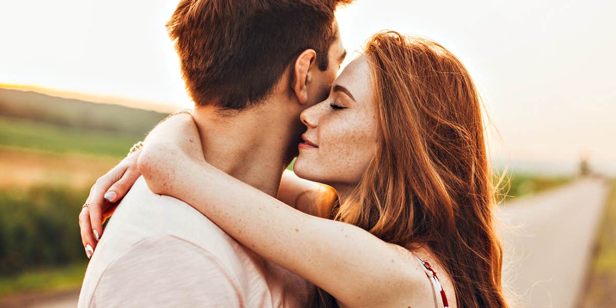 How self-critical people destroy relationships Redheaded woman hugging man who is turning away, country road in the evening