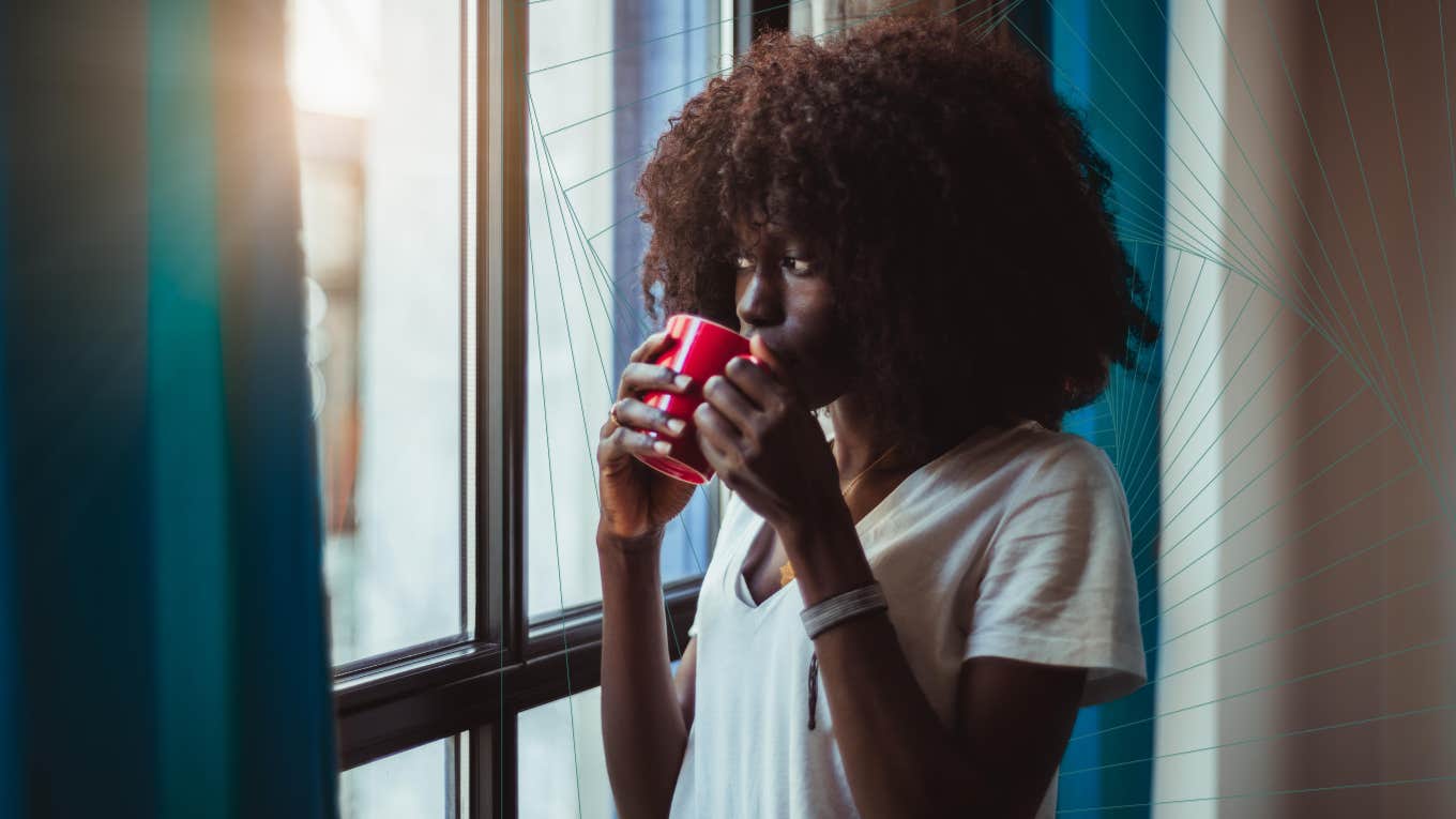 woman drinking tea and looking out window