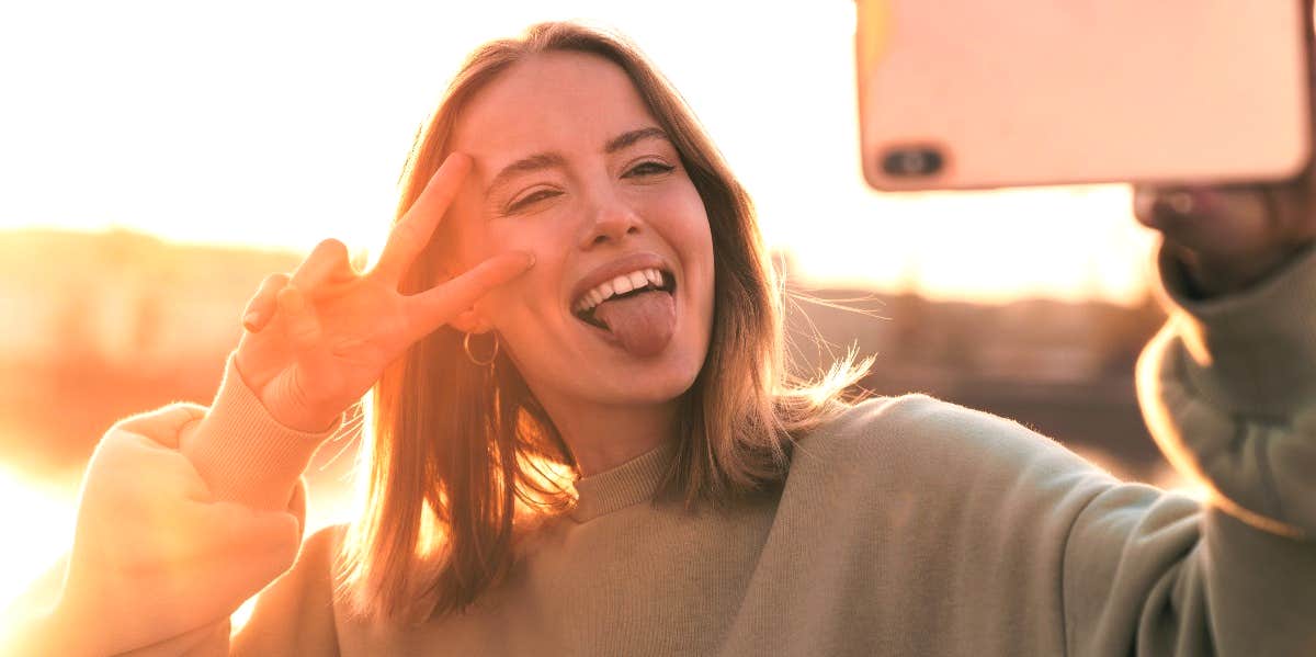 Woman posing for selfie sitting in bed stock photo (147100) - YouWorkForThem