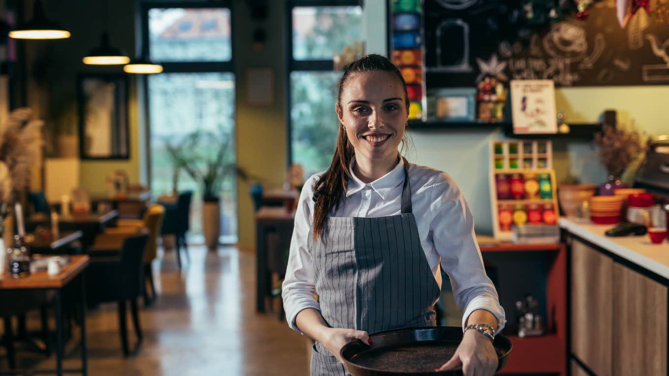 server holding tray in restaurant