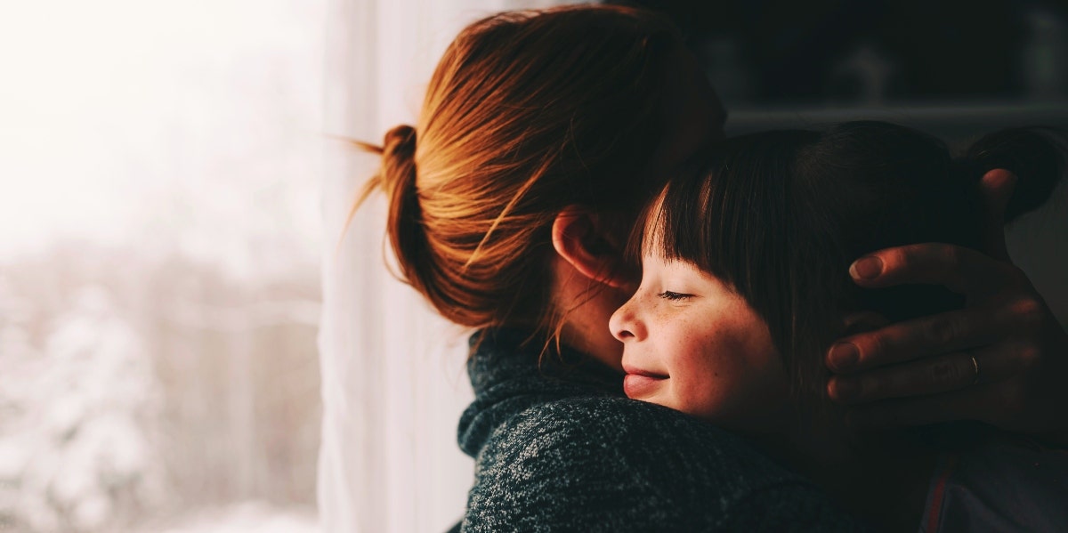 woman hugging little girl