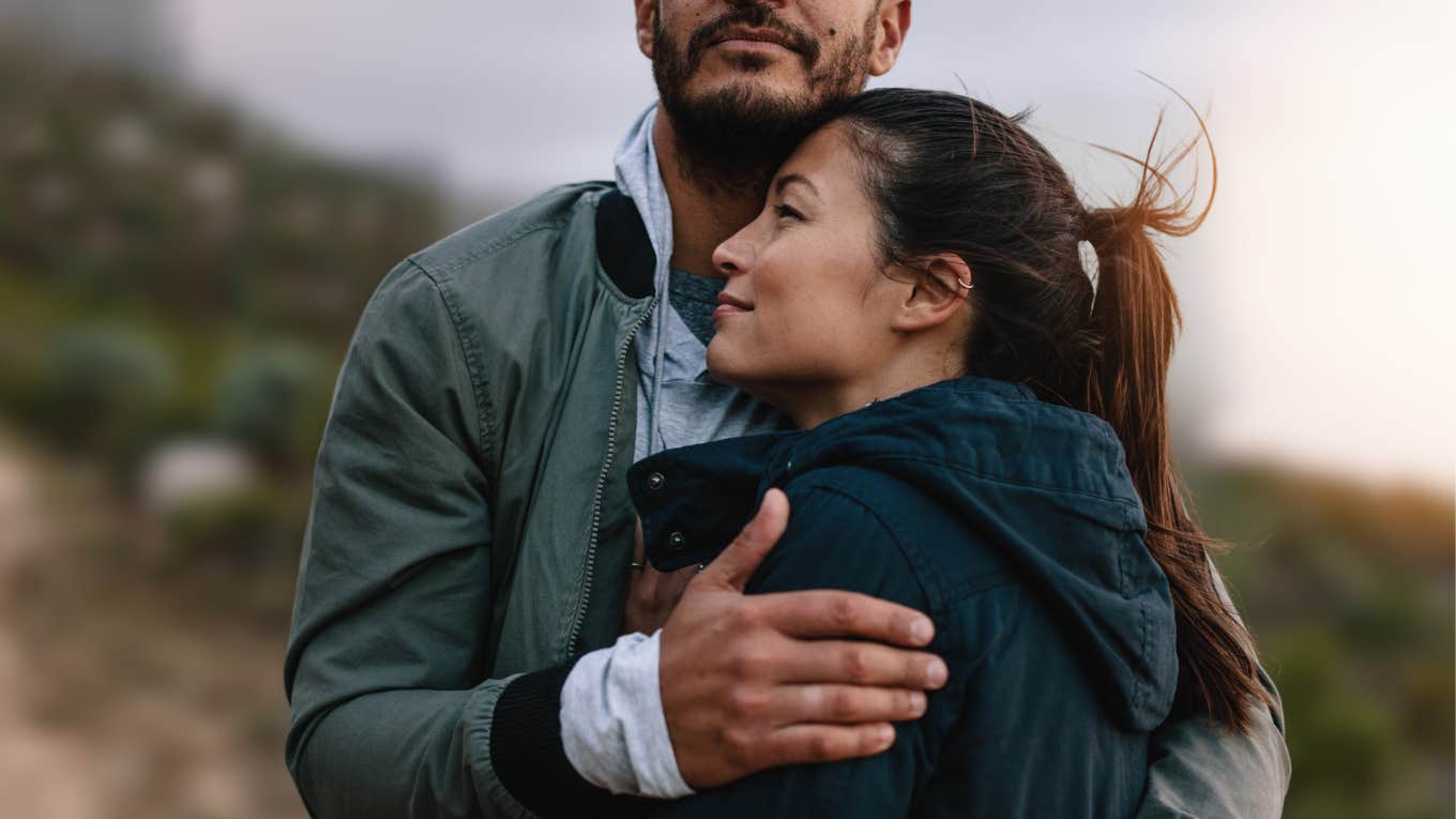 Young couple hugging each other and smiling. 