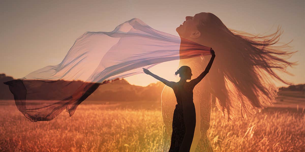 woman in field at sunset