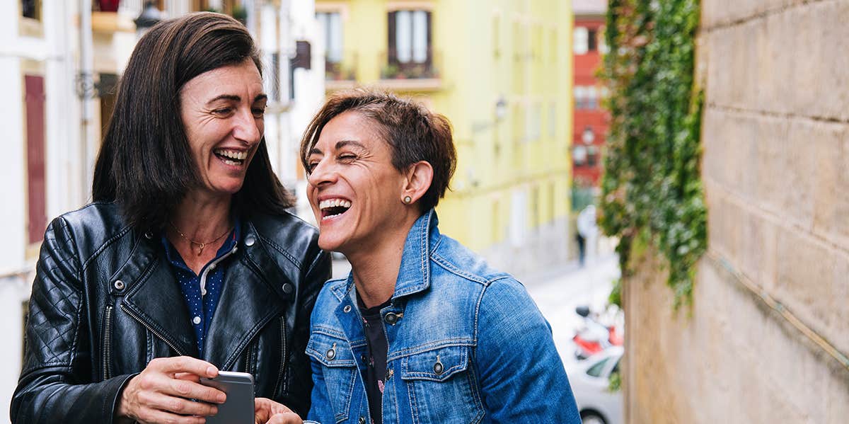 two middle aged women laughing 