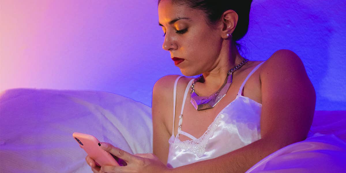 woman in nightgown texting from bed