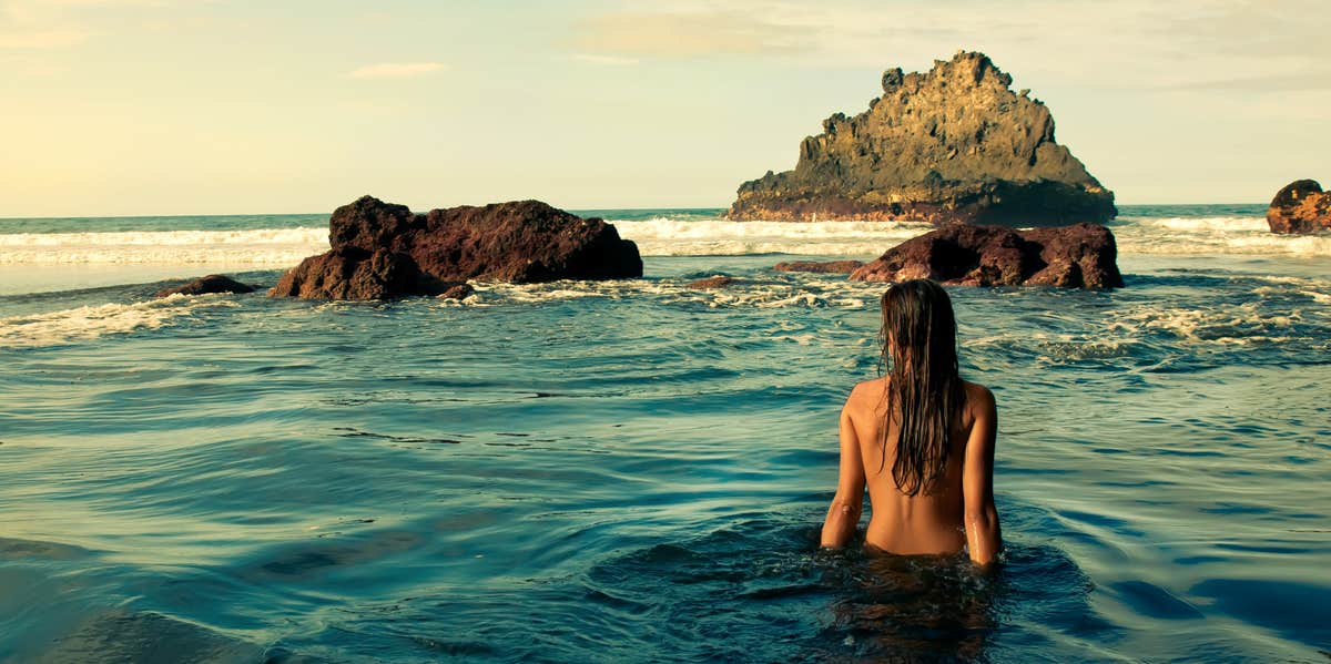 Two alluring women are relaxing on the nudist beach