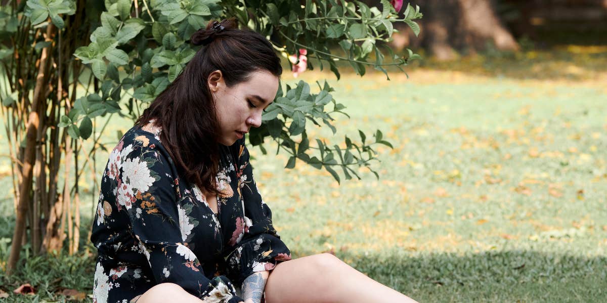 She Tells Her Grandma She's Been Cheated On — And Grandma Gives Incredible Advice sad woman on grass