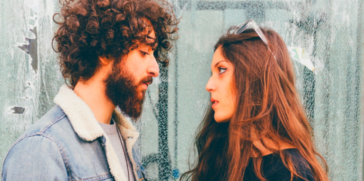 Should Your Partner Stand Up For You, Even If You're Wrong? man and woman staring at each other fighting upset
