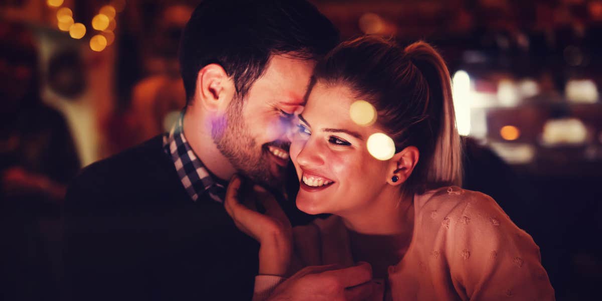 woman and man nuzzle in a restaurant 