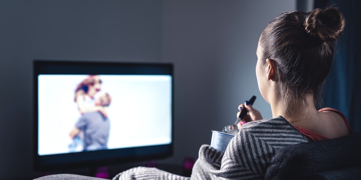 woman watching couple on tv and eating ice cream