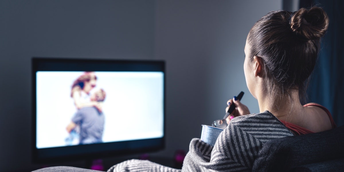 single forever woman watching couple on tv and eating ice cream
