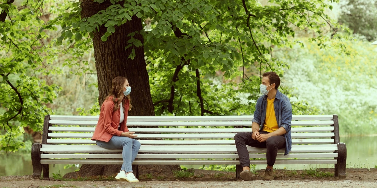 man and woman on socially distanced date in the park