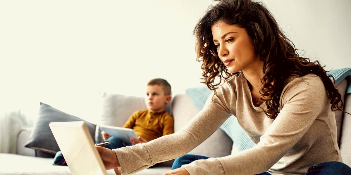 Side hustle Woman working at home with child in background