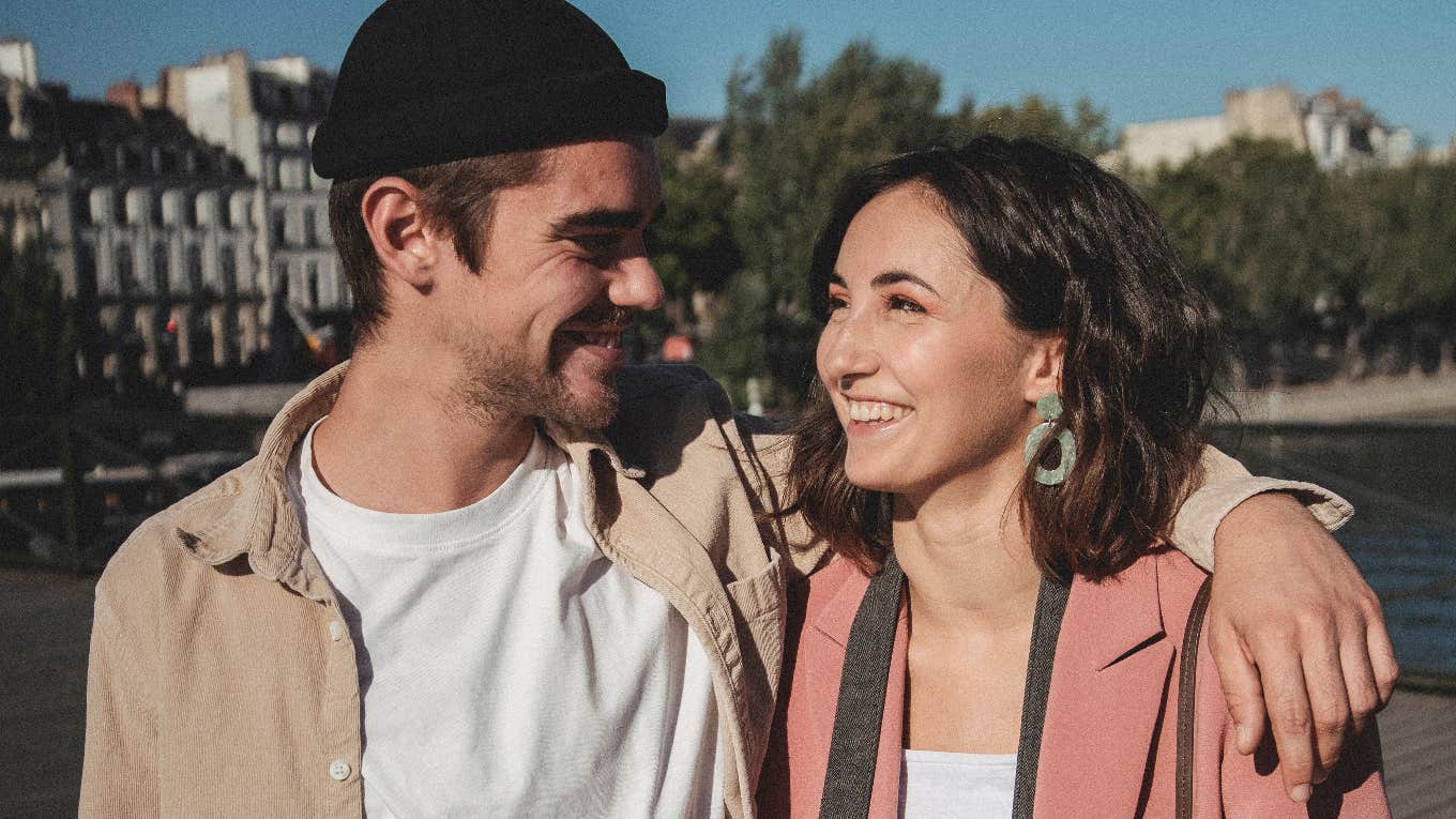 man with arm around woman's shoulders