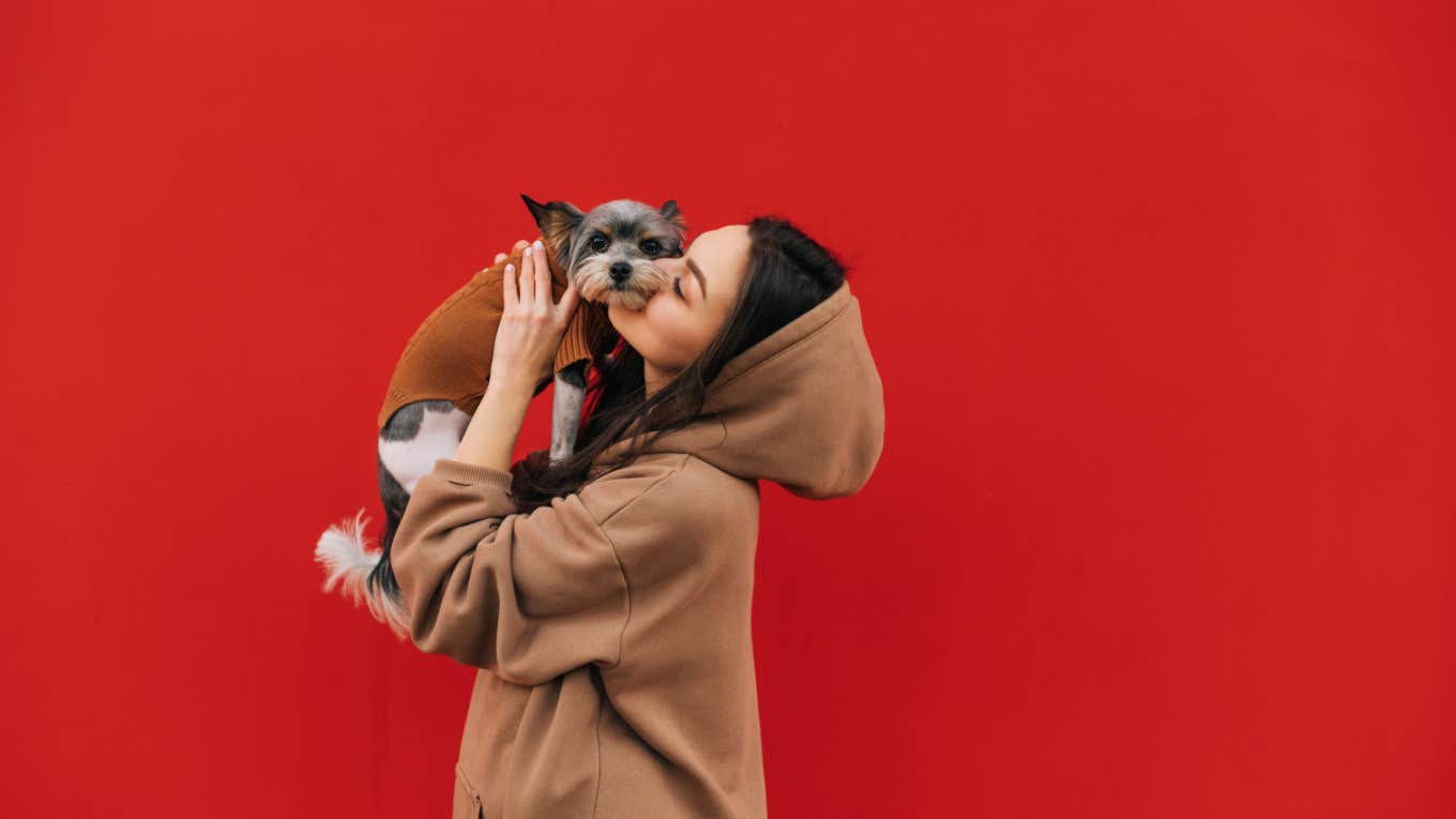 woman kisses dog affectionately