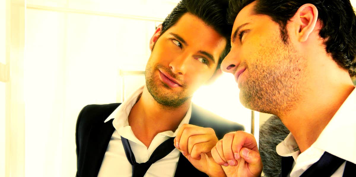 8 Signs Your Man's Ego Is Killing Your Relationship man with a big ego looking at himself in the mirror