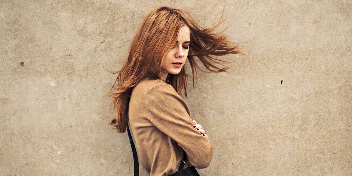 Run-As-Fast-As-You-Can Signs Of Abuse In A Relationship woman looking despondent against taupe wall