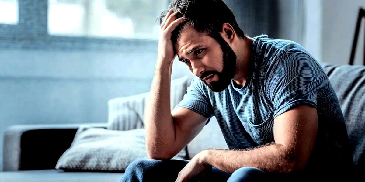 emotionally unstable man sitting with his head in his hand