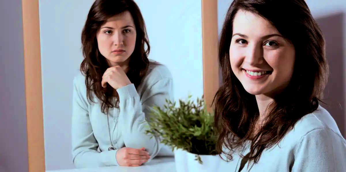 woman smiling at the camera while her mirror image gives her a mean look