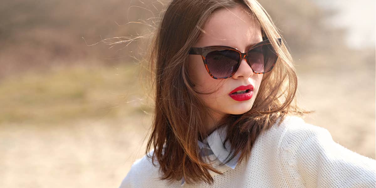Young brunette with red lips and sunglasses with an attitude 