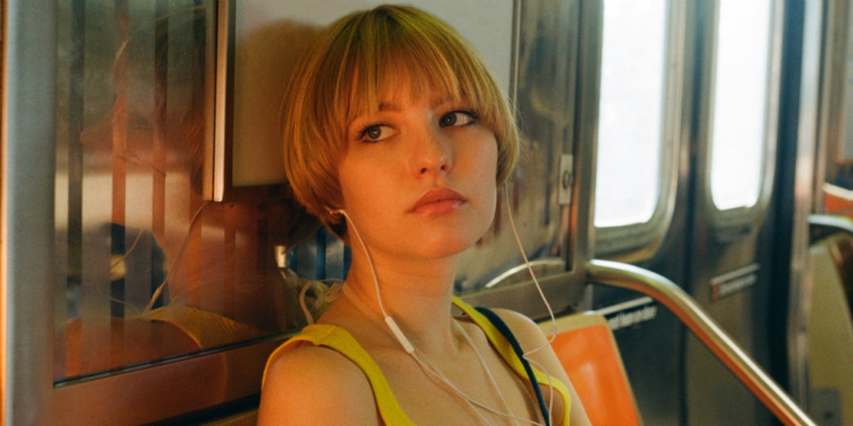 woman with headphones on subway