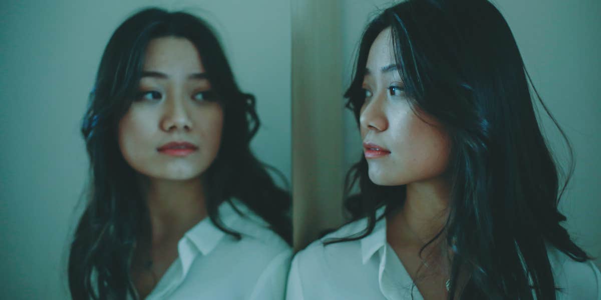 Woman looking at reflection in mirror