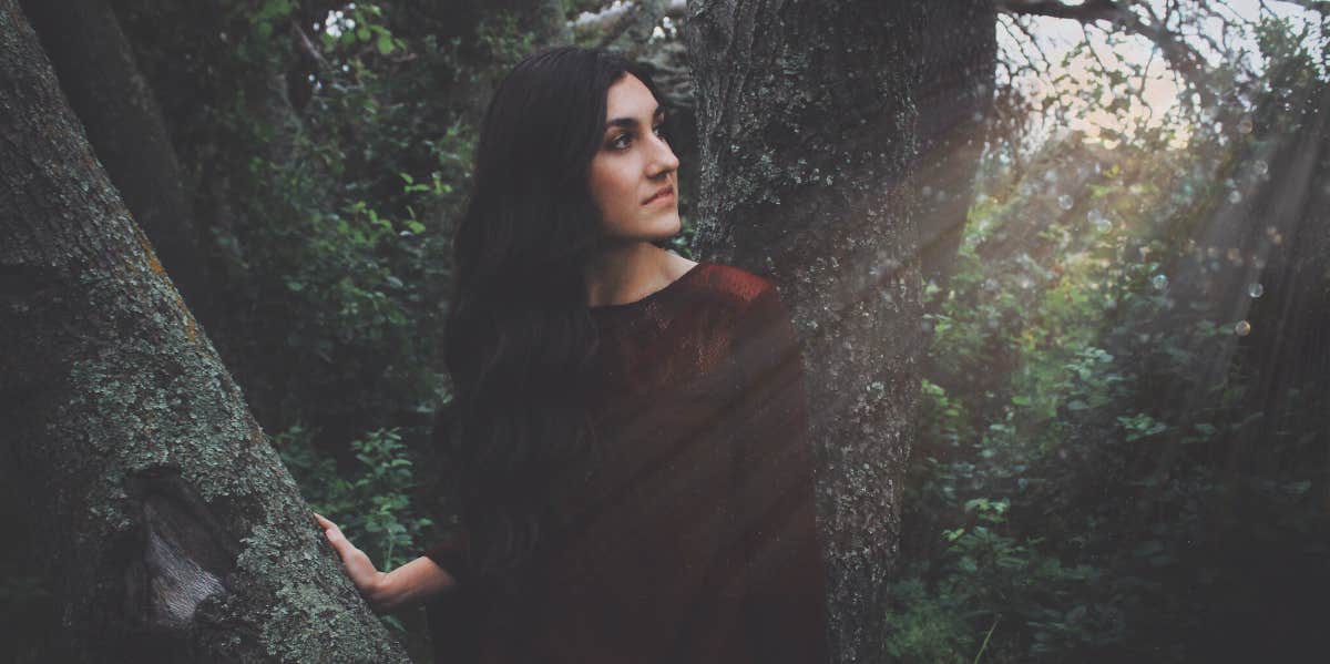 woman leaning near tree