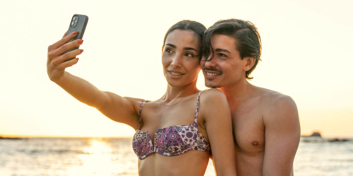 couple taking selfie on the beach