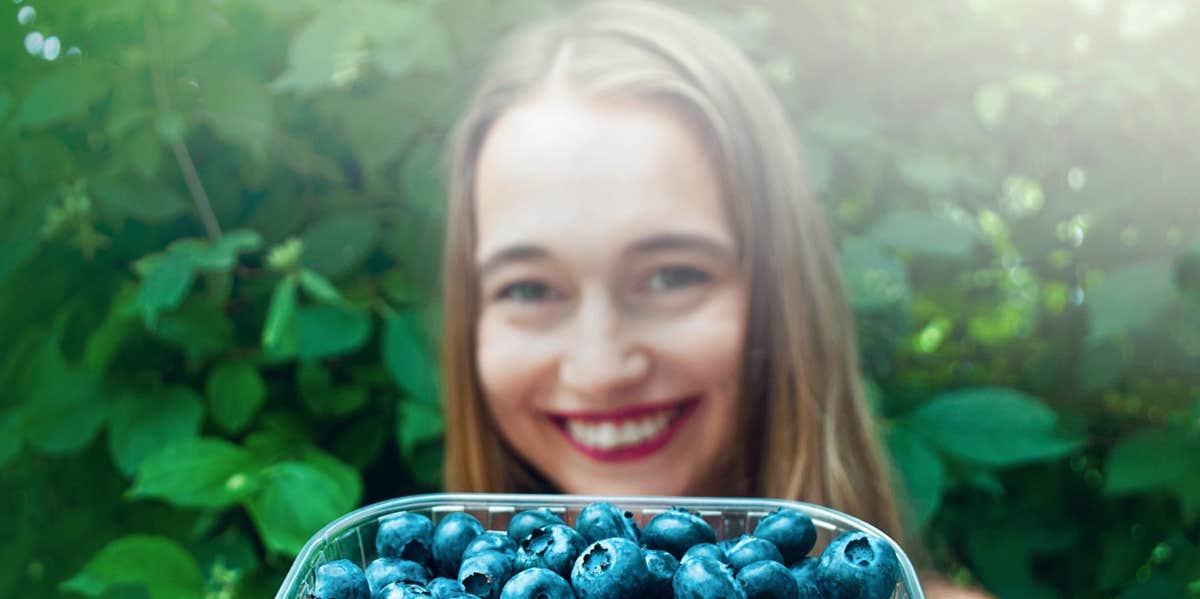 woman holding blueberries