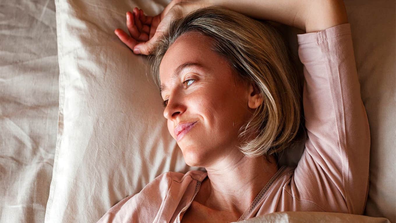 5 Simple Things To Do Before Bed If You're Trying To Lose Weight woman in bed smiling